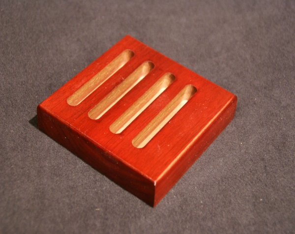 Custom mouldings and dimension can be made into a variety of items such as this slotted wooden soap dish stained red.